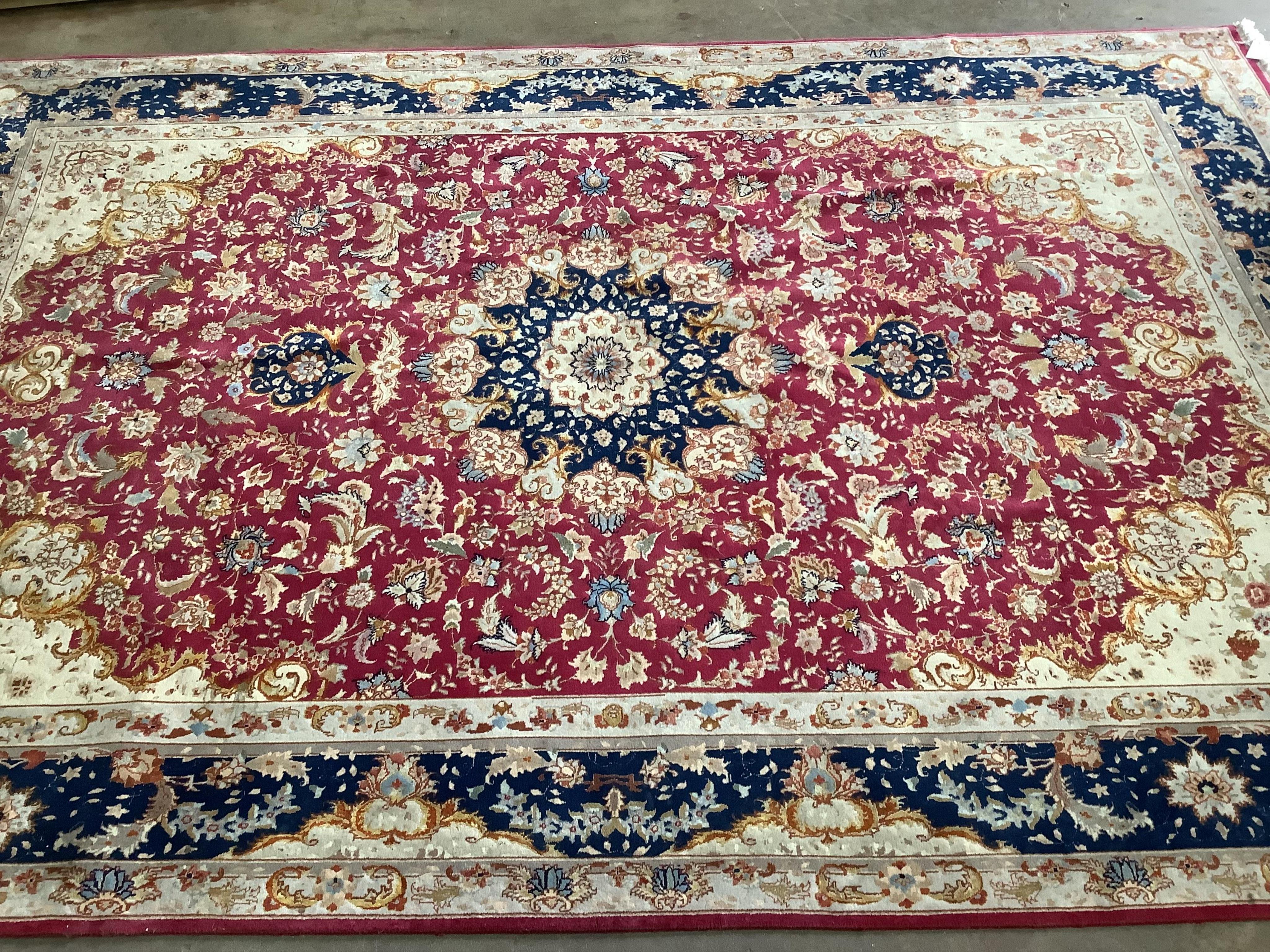 A Tabriz burgundy ground carpet, 300 x 200cm. Condition - fair